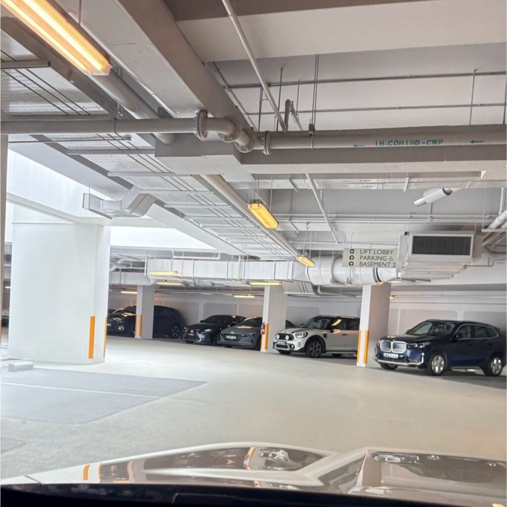 An immaculate, modern airport parking garage in Singapore with clean concrete floors completely free of tire tread marks.