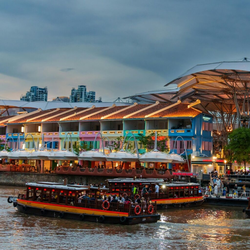 scenic view of Singapore architecture, showcasing a preserved historic colonial shophouse framed by a modern glass skyscraper under a clear blue sky.