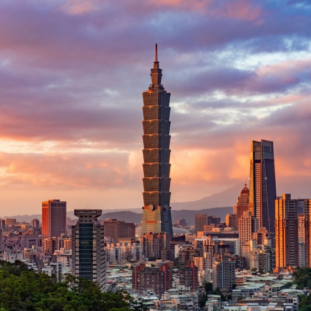The iconic Taipei 101 skyscraper at sunset surrounded by the sprawling cityscape.