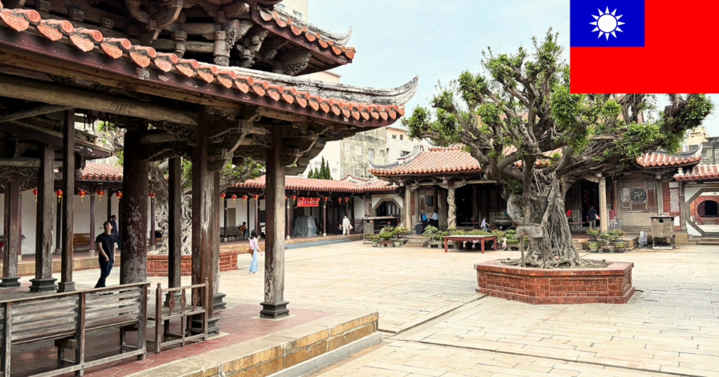 Historic traditional temple in Lukang, Taiwan, featuring intricate red and wooden architecture with the Taiwanese flag visible in the corner.