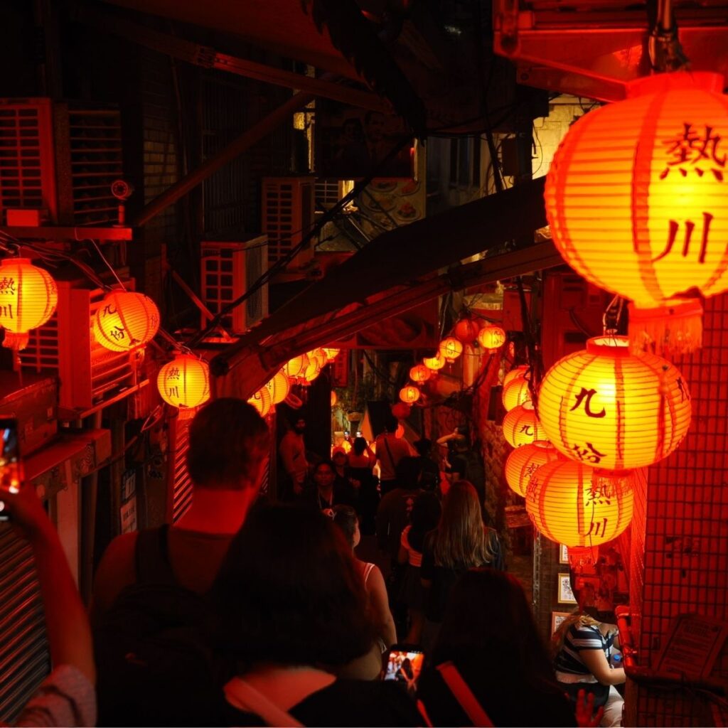 Looking down the steps of a narrow street lined with glowing red lanterns in historic Jiufen.