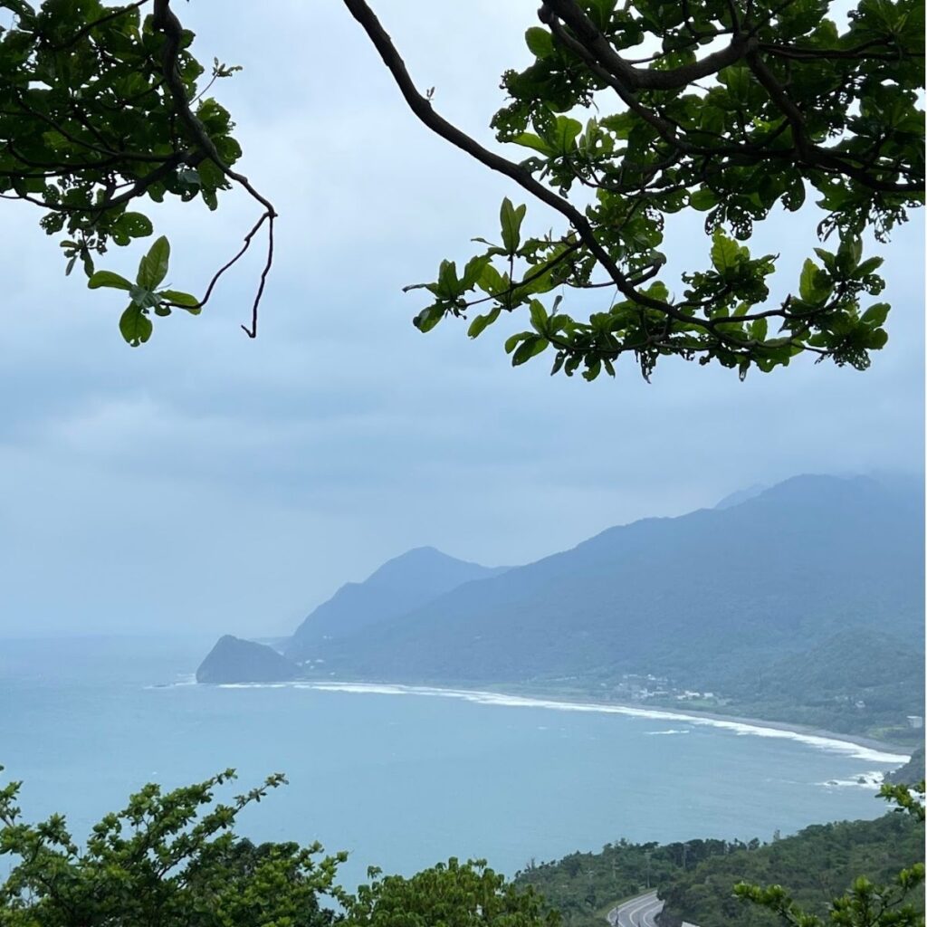 Panoramic view of a mountain-backed ocean cove from a scenic Hualien service station.